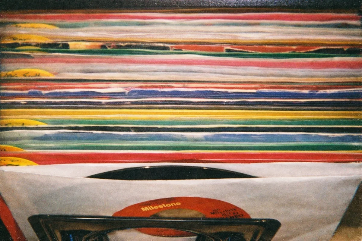 Rows of seven-inch records in white paper sleeves inside a crate.