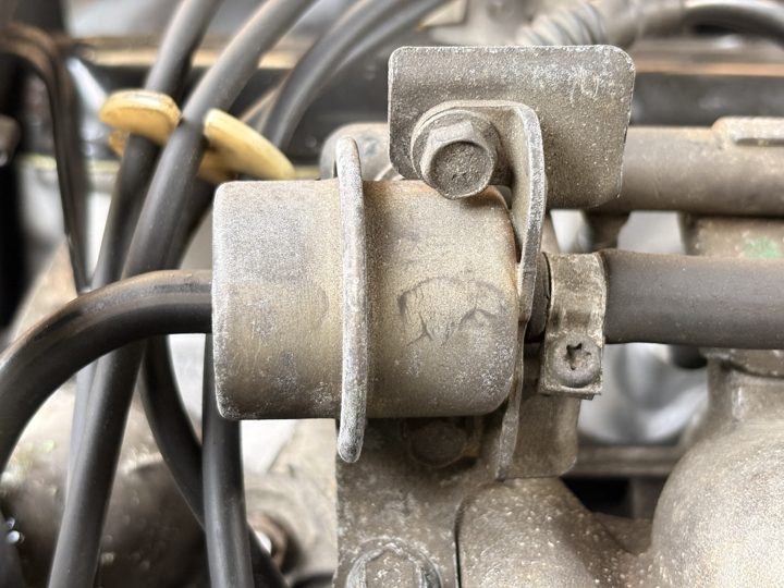 The old fuel pressure regulator, a grimy canister in a nest of fuel and vacuum lines.